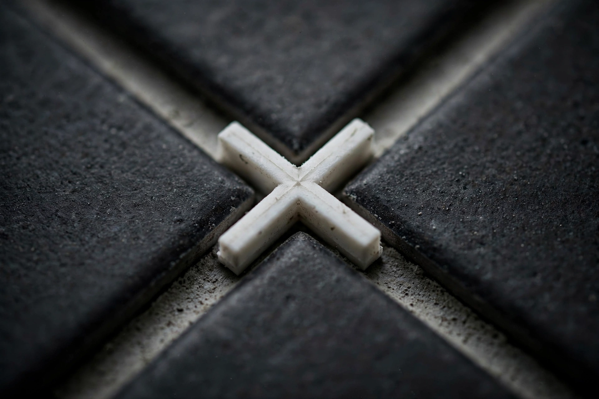 Close-up of grout lines with a tile spacer cross